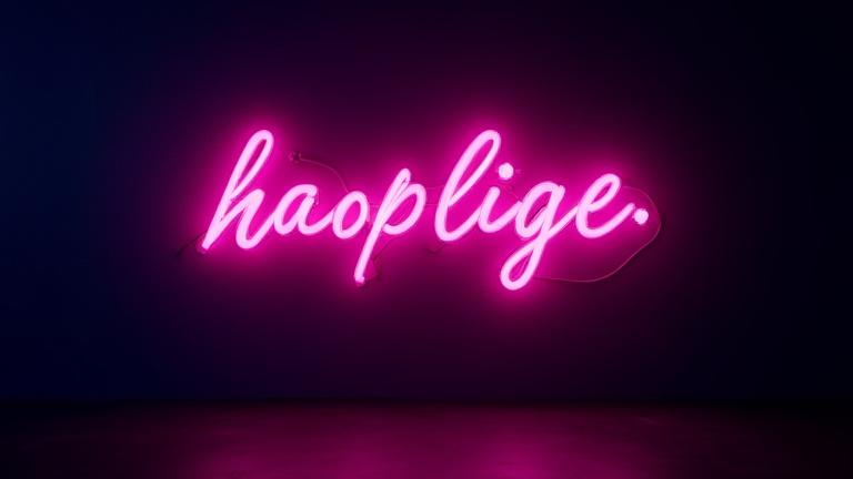 Modern LED neon skylt som lyser med starka färger i ett mörkt rum